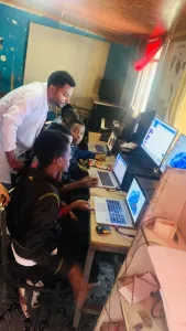 3 teacher guiding student on computer